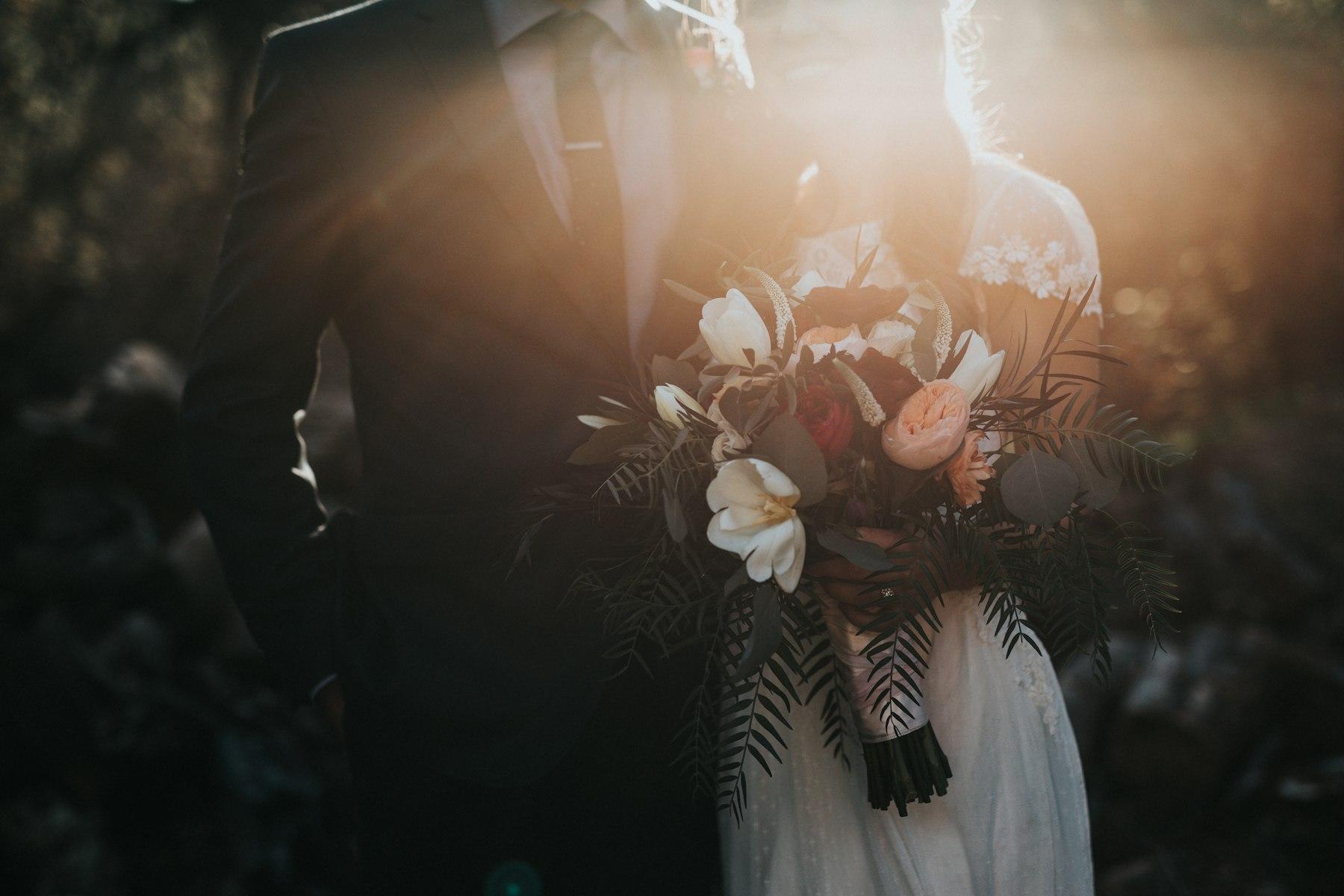 A couple in wedding attire, photographed in warm evening light